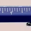 Blue pen with a ruler on a pink background
